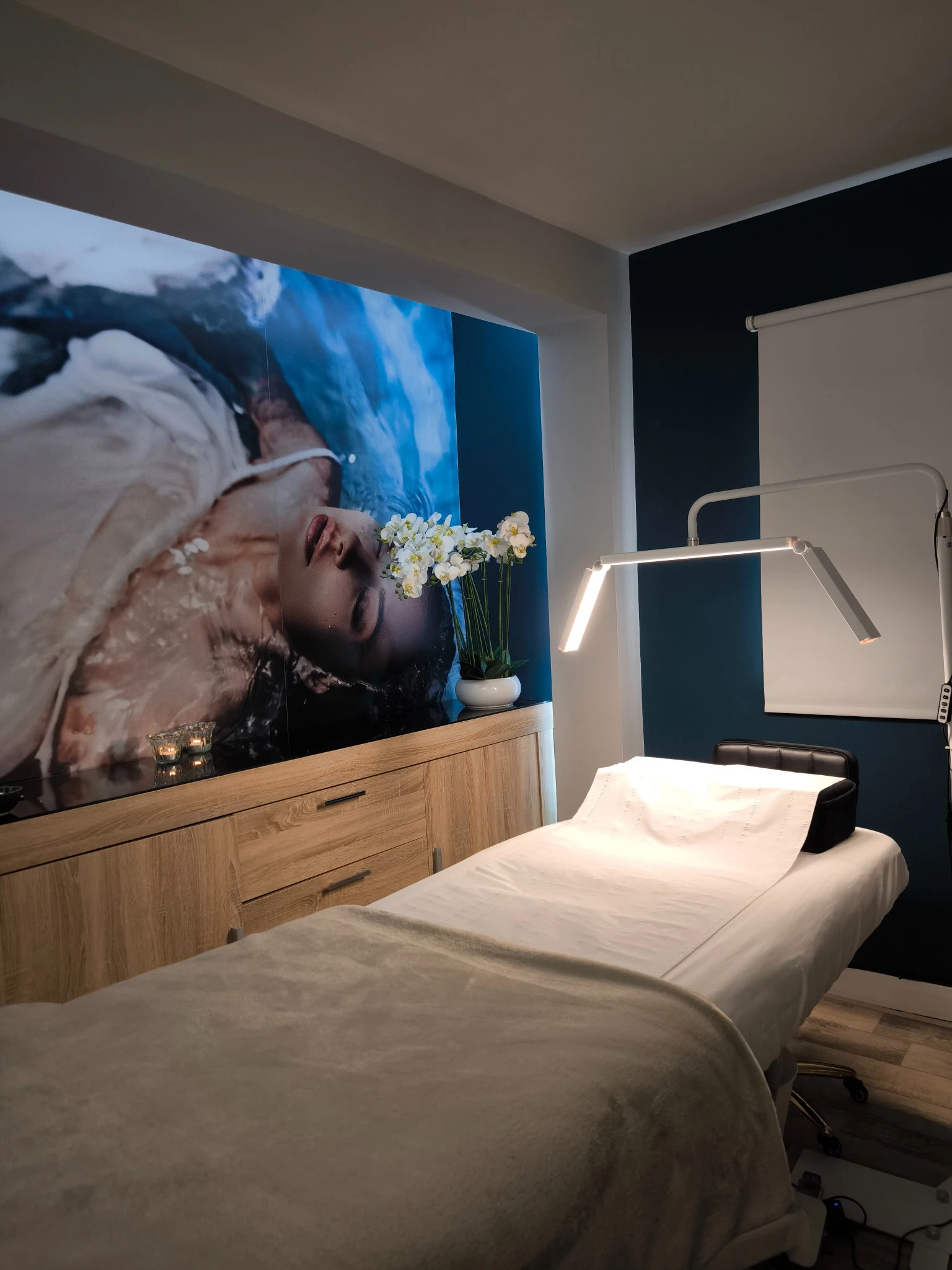 Treatment room at The Beauty Room Naas, with blue wall, orchid and prepared treatment couch